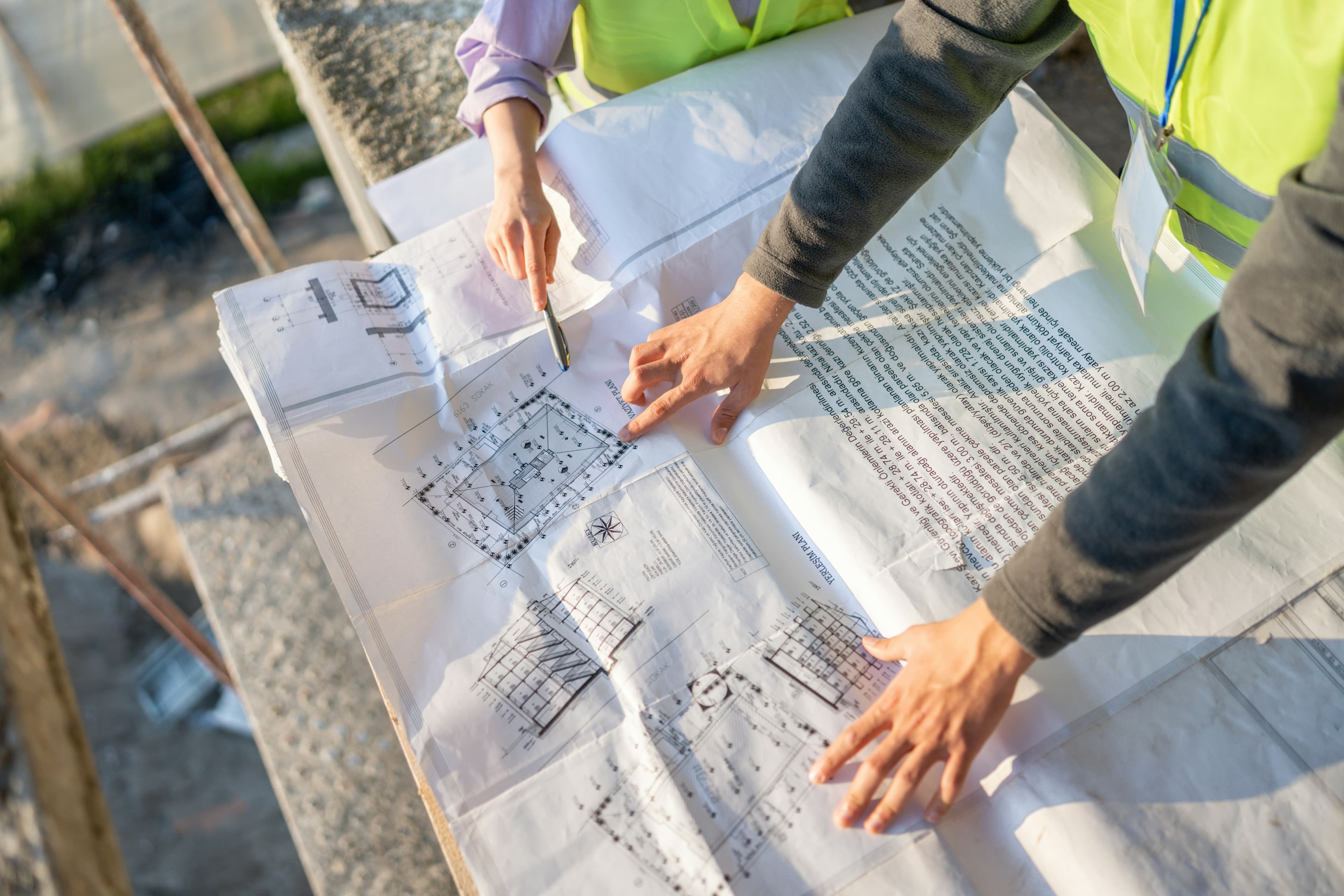 Construction professionals reviewing plans on an active job site