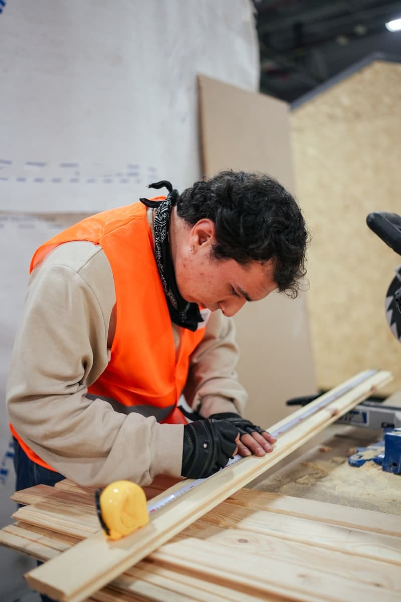 Contractor marking measurements on lumber in a workshop